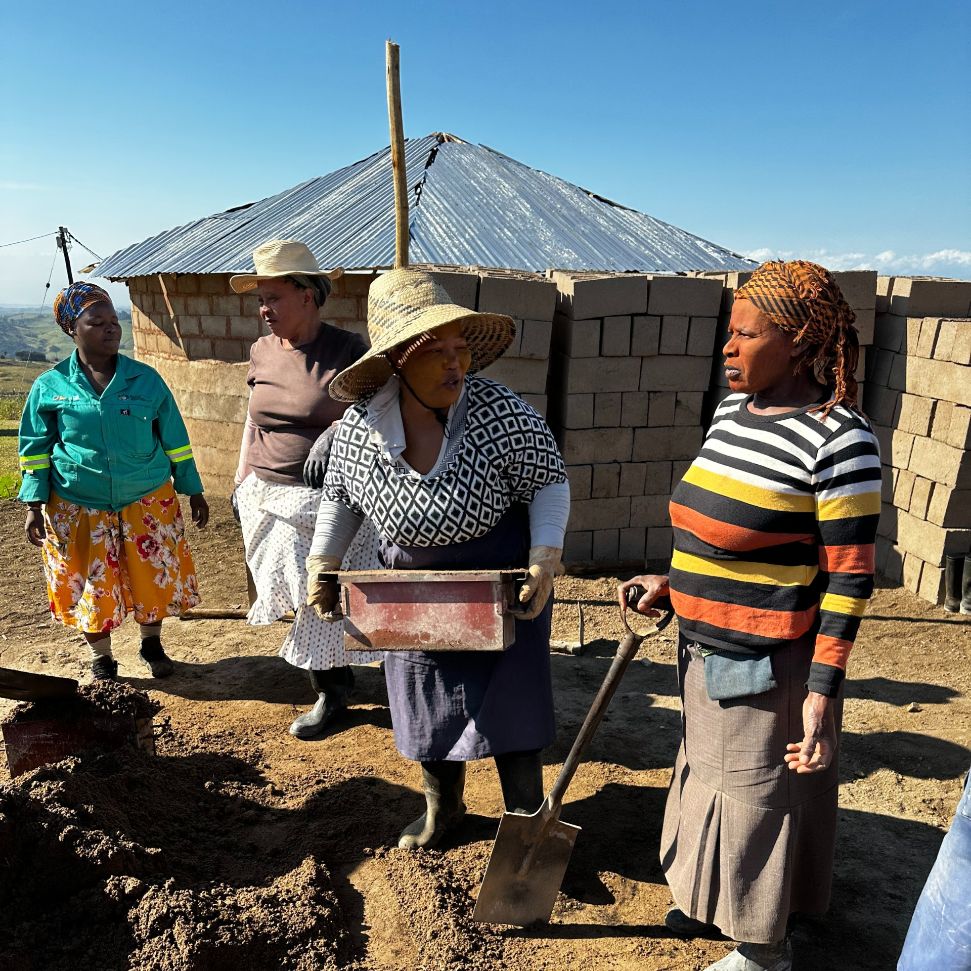 Women filling moulds with cement to make bricks