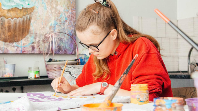 Teenager painting on a tote bag